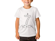 a young boy wearing a white t - shirt with a candle on it