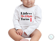 a baby sitting on the ground wearing a onesie