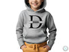 a young boy wearing a grey hoodie with the letter d on it