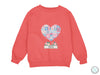 a pink sweatshirt with a patchwork heart on it